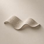 A wavy, perforated ceramic planter or decorative pot in a warm off-white/cream color, shown against a matching neutral beige background.